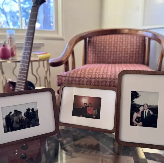 Three Pop-up Frames with instant photos on a glass table in a living room