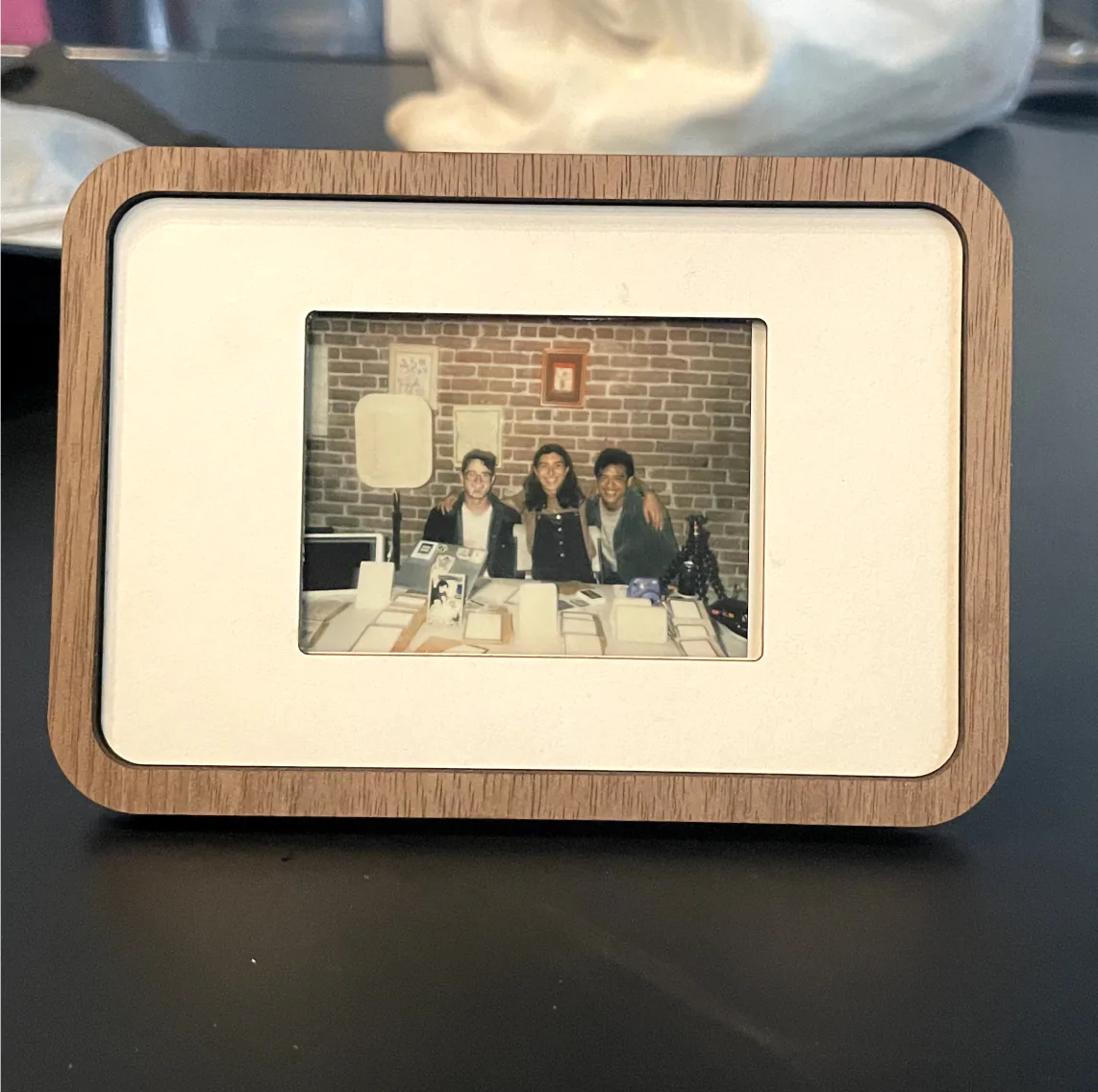 Pop-up Frame on a desk with a photo of four friends at a party