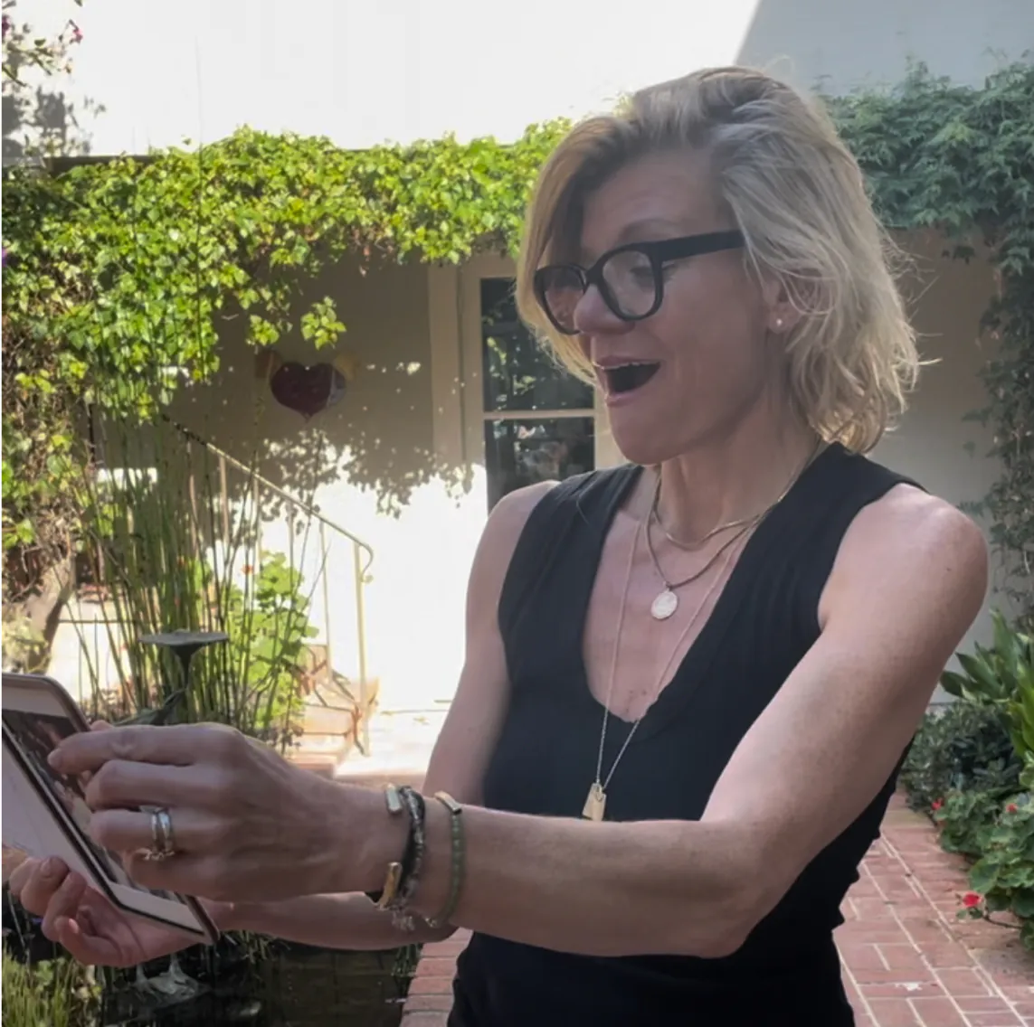 A woman opening a Pop-up Frame card, delighted